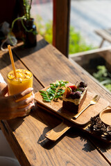 Fruit cake decorated with figs, cookies and blueberries with iced fresh mango smoothies glass