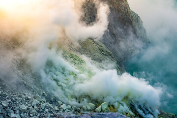 Ijen volcano crater with lake and sulphur mining. Beautiful Landscape mountain and green lake with smoke sulfur in the morning in a Kawah Ijen volcano. Beautiful landmark from East Java, Indonesia