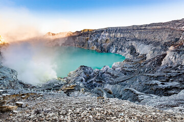 Ijen volcano crater with lake and sulphur mining. Beautiful Landscape mountain and green lake with smoke sulfur in the morning in a Kawah Ijen volcano. Beautiful landmark from East Java, Indonesia