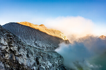 Mountain furrows wave surface pattern from lava flow at the top of Ijen volcano crater.Beautiful Landscape mountain and green lake with smoke sulfur in a Kawah Ijen volcano.East Java, Indonesia