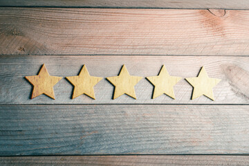 5 Golden Stars Lying Down On Wooden Board - View From Above - Top Quality Concept