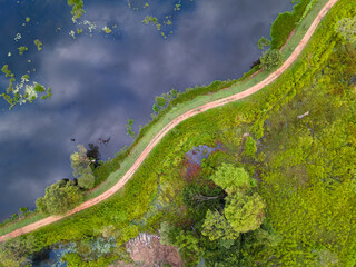 Arial view of a lake with trees grown inside and a road going along in Sri Lanka 