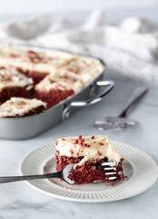 Close up of a red velvet chocolate brownie square with a fork full in front.