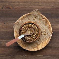 Fototapeta na wymiar A wooden bowl filled with toasted sunflower seeds ready for snacking.