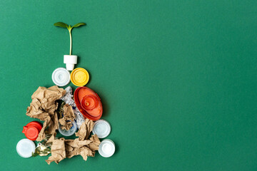 Green plant on pile of different types of waste