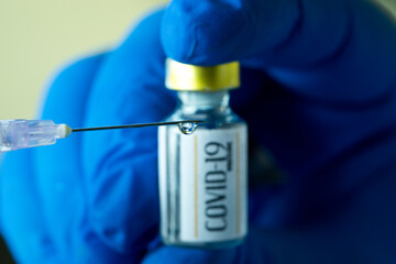 Doctor preparing injection with covid-19 vaccine closeup