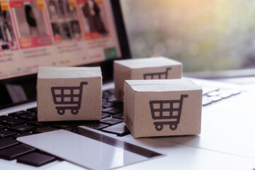 Online shopping. Credit card and cardboard box with a shopping cart logo on laptop keyboard. Shopping service on The online web. offers home delivery.