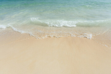 Fototapeta na wymiar Soft wave of sea on empty sandy beach Background with copy space.