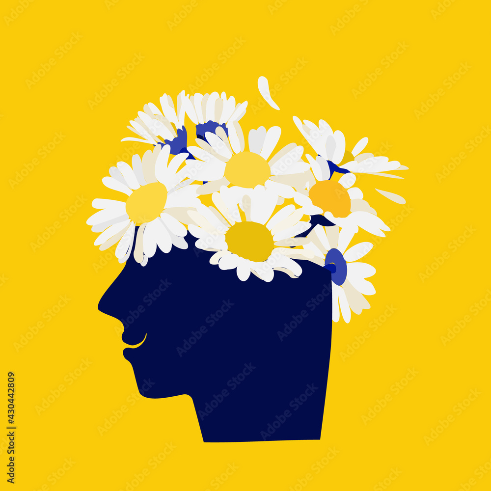 Wall mural Mental health concept. Abstract image of a head with flowers inside. Chamomile, flowers and leaves as a symbol of inspiration, calmness, favorable mental behavior.