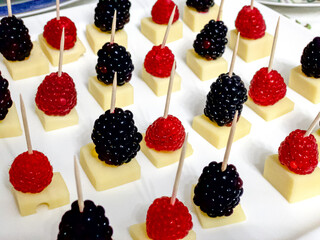 blackberries and raspberries on cheese pieces
