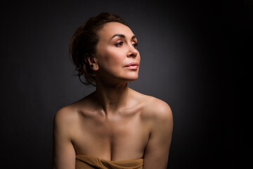 Fototapeta premium portrait of a sensual fifty year old woman on grey studio background