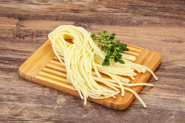 Chechil spaghetti cheese over board