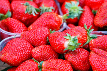 Berries of ripe large red strawberries close-up on a market counter.