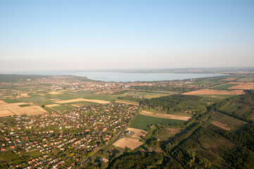 Panoramic view from a hot air balloon to Lake Balaton and residential buildings.
