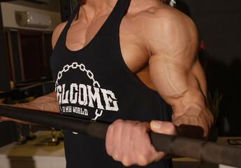 Attractive tall muscular bodybuilder doing heavy deadlifts in modern fitness center