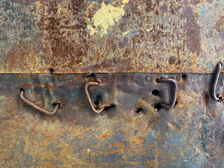 Rusty metal wall, rusty crooked nails, old. Nails are driven into the metal wall