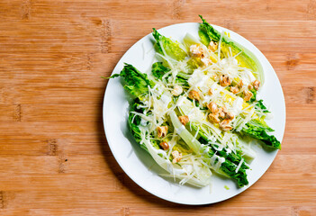 Caesar salad. Classic American salad with romaine, Caesar dressing, red onions, bacon lardons, Parmesan cheese, olive oil, lemon juice, salt and pepper. A Fine dining restaurant classic.