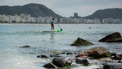 Woman floating in a canoe. Copacabana Fort