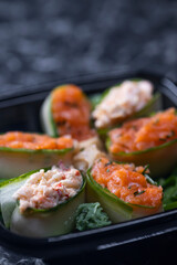 set of sushi rolls with seafood on a black stone background