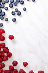 still life with blueberries, strawberries and raspberries on a white patterned background