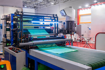 Cutting bag making machine with flat polyethylene green film at exhibition, trade show....