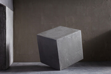 Concrete cube near wall background texture. Art or construction concept of minimalism design