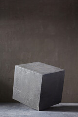 Concrete cube near wall background texture. Art or construction concept of minimalism design