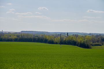 Beautiful summer landscape with green grass and a church in the distance