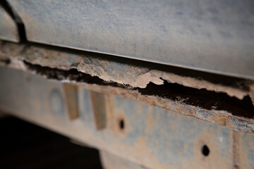 Rust on the car. An old car with rust holes in it.