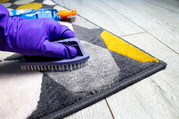 Carpet cleaning. Gloved hand and cleaning brush.