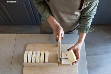 A woman makes handmade natural soap.The finished soap is cut into pieces using special machine. Home spa. Small business