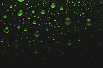 Sparkling drops of water on a color background. Selective focus. Green. Toned