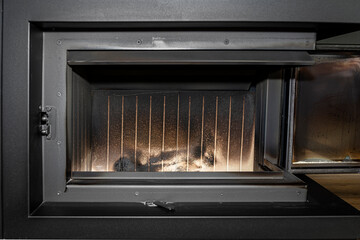 Ceramic chamber in a modern fireplace with a closed combustion chamber standing in the living room, fireplace interior.