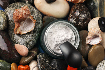 Hydrolyzed marine collagen powder in a glass jar on a background of stones. Natural supplement. Healthy lifestyle concept. Close-up