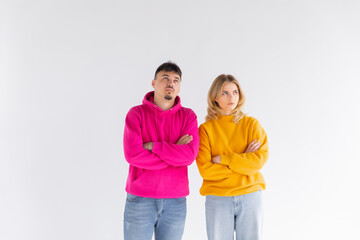 Image of happy young people man and woman in basic clothing throwing up arms with puzzlement isolated over white background