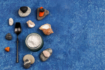 Obraz na płótnie Canvas Hydrolyzed marine collagen powder in a glass jar among stones on a blue background. Natural supplement. Healthy lifestyle concept. Copy space
