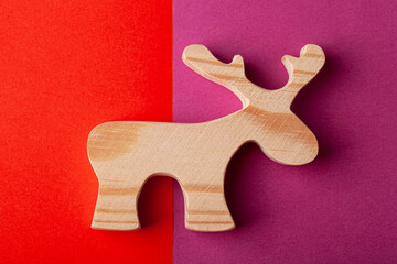 A figurine of an elk or a deer carved from solid pine with a hand jigsaw. On a multi-colored background
