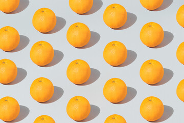 Pattern made with fresh orange on the gray background. Minimal fruit or food concept. Flat lay, top view.