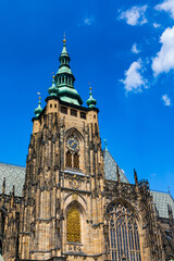 Fototapeta na wymiar Prague, bell gothic towers and St. Vitus Cathedral. St. Vitus is a Roman Catholic cathedral in Prague, Czech Republic. Panoramic view from the courtyard to the south facade. Prague, Czechia.