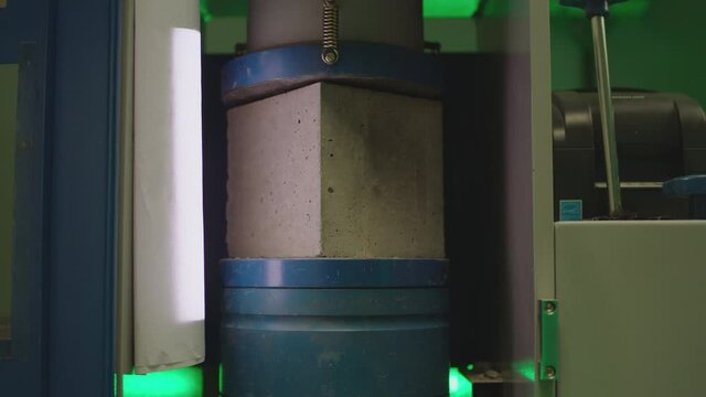 Concrete block breaks under high pressure . Hydraulic press is creating pressure on cube made of concrete. Strength testing .
Concrete cube compressive strength test . Shot on ARRI ALEXA cinema camera