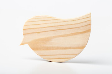 A figurine of a bird carved from solid pine by a hand jigsaw. On a white background