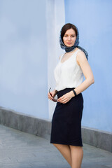 Beautiful stylish young woman, young brunette woman in a black skirt and white shirt.
