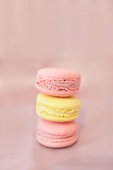 Pink yellow macaroons on pink background. Macro shot of a stack of pink and yellow macaroons on a purple paper background. French Dessert. Selective focus