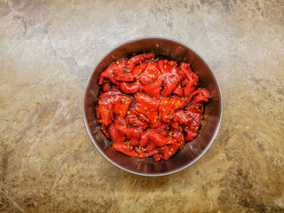 Marinated beef strips in a metal container prepared for drying for a beef jerky