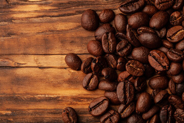 Roasted coffee beans on the old dark wooden background for wallpaper or decor