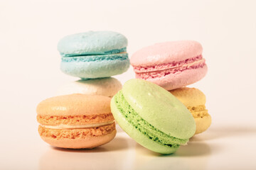 Colorful cake macaroons on a light background. Toned