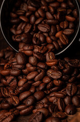 Roasted coffee beans on the old dark wooden background for wallpaper or decor