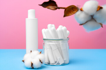 Female medical tampons on pink and blue background