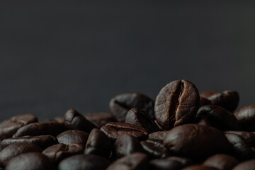 Roasted coffee beans on the old dark wooden background for wallpaper or decor. Shallow depth of...