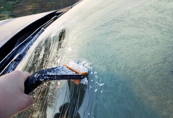 Scraping the ice from windshield of the car